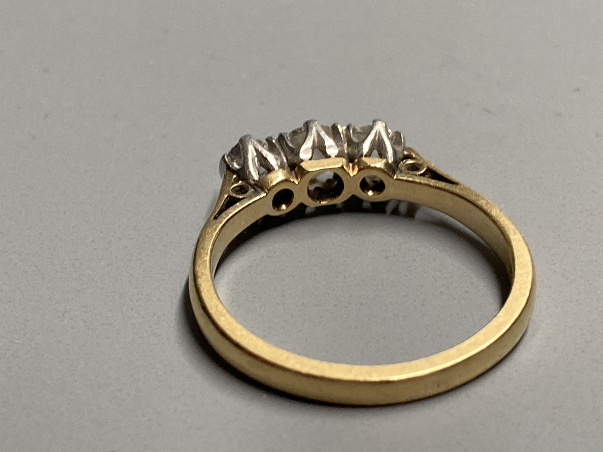 A mid 20th century 18ct and three stone diamond ring, size K/L, gross 2.7 grams.